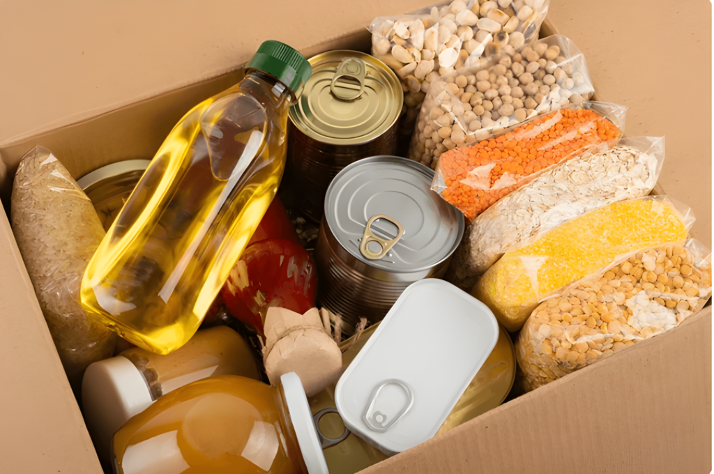 Box filled with essential food supplies including canned goods, grains, and cooking oil, representing survival and preparedness.