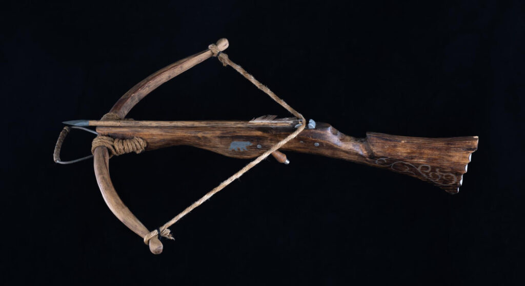 Traditional wooden survival crossbow on black background