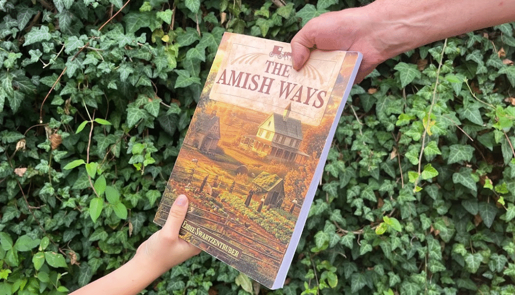 Hands exchanging The Amish Ways survival book outdoors