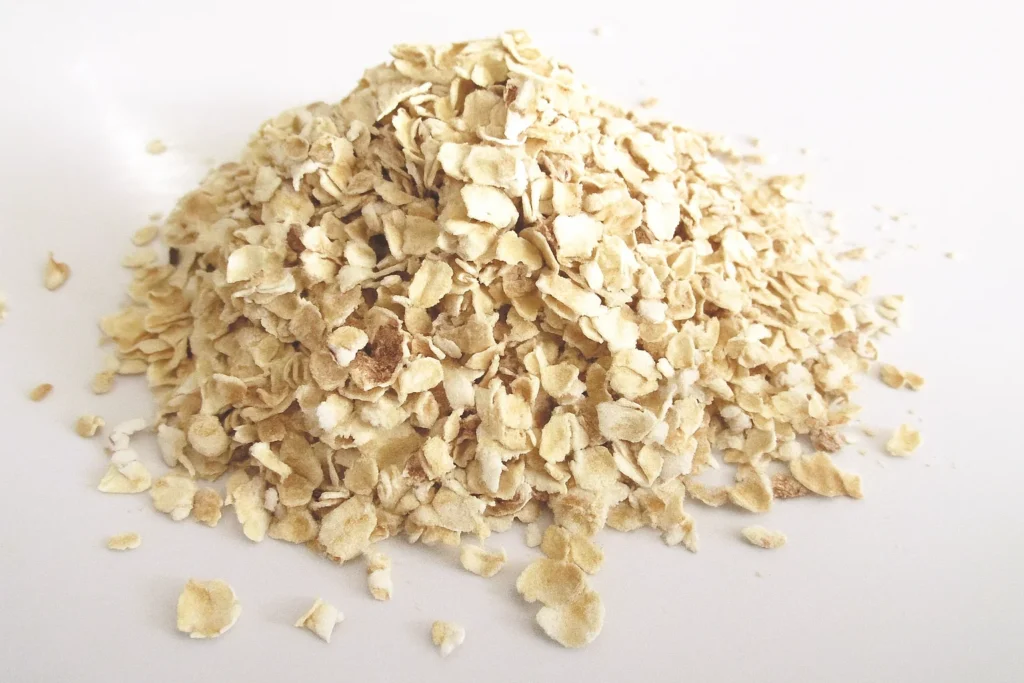 Pile of rolled oats on a neutral background, showing a simple long-lasting survival food rich in beta-glucans for immune support.