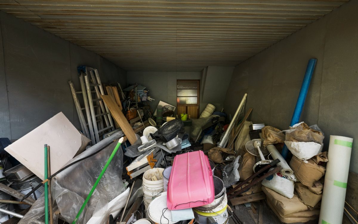 Cluttered storage space with various household items and tools, highlighting the importance of decluttering a prepper stockpile.