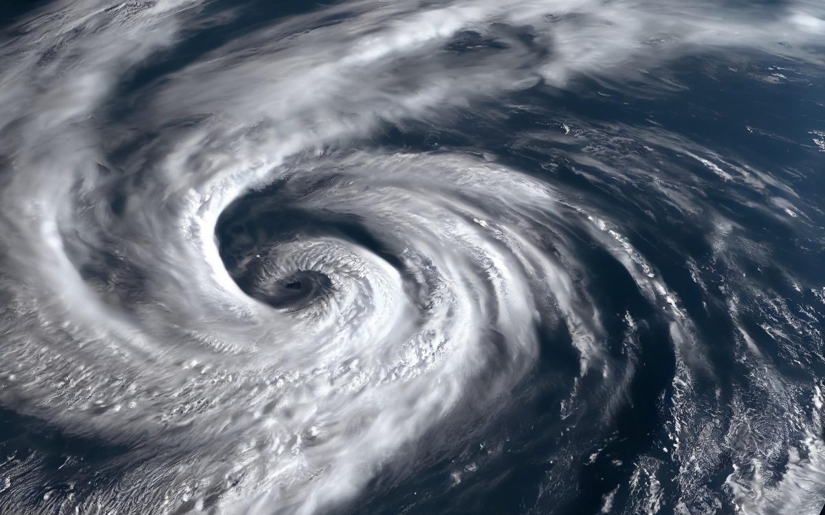 Satellite view of a powerful hurricane swirling over the ocean, showcasing its massive spiral cloud formation.