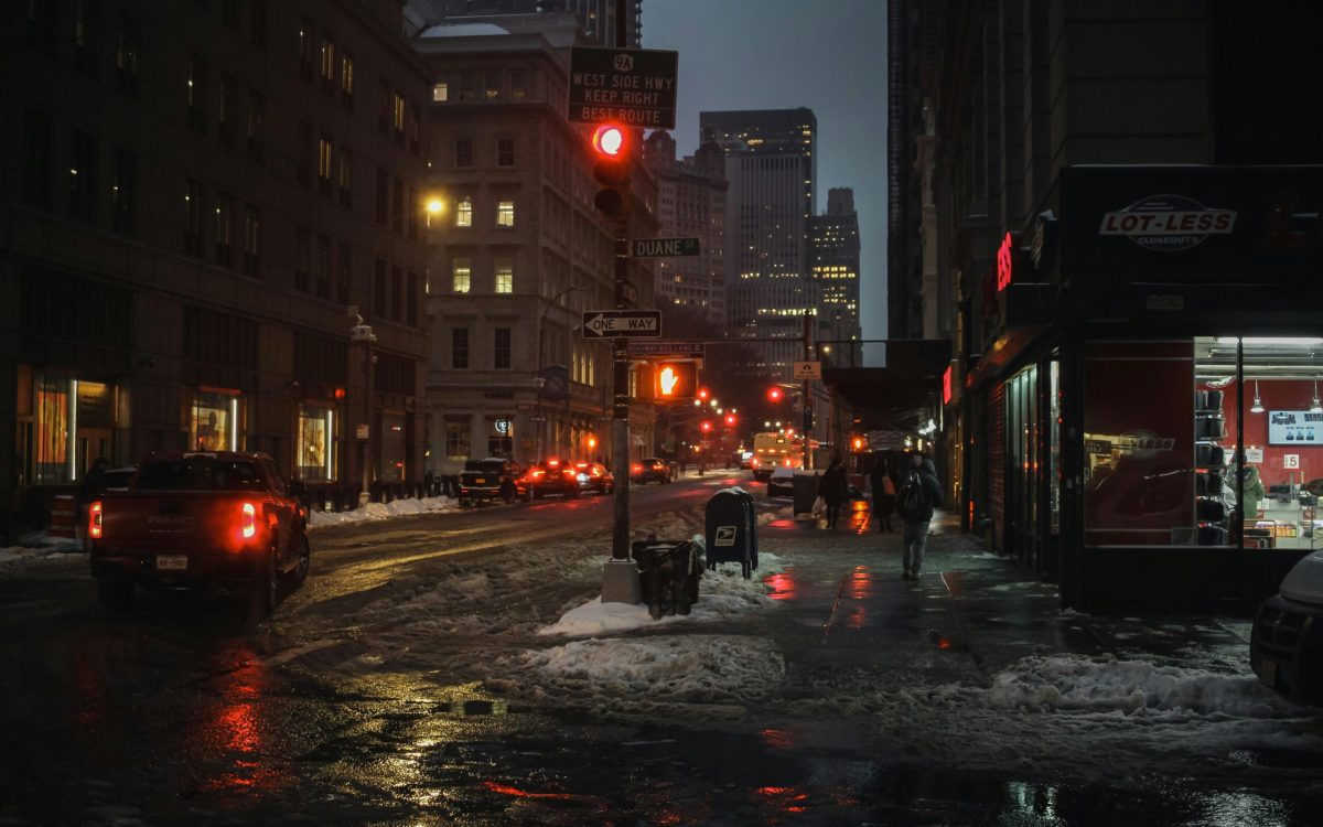 City street at night during power outage with wet roads and dim lighting